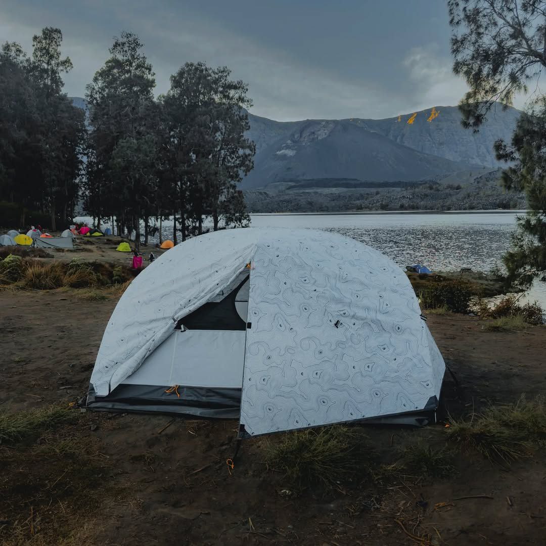 Tenda hiking warna biru dengan kapasitas 4 orang di alam terbuka